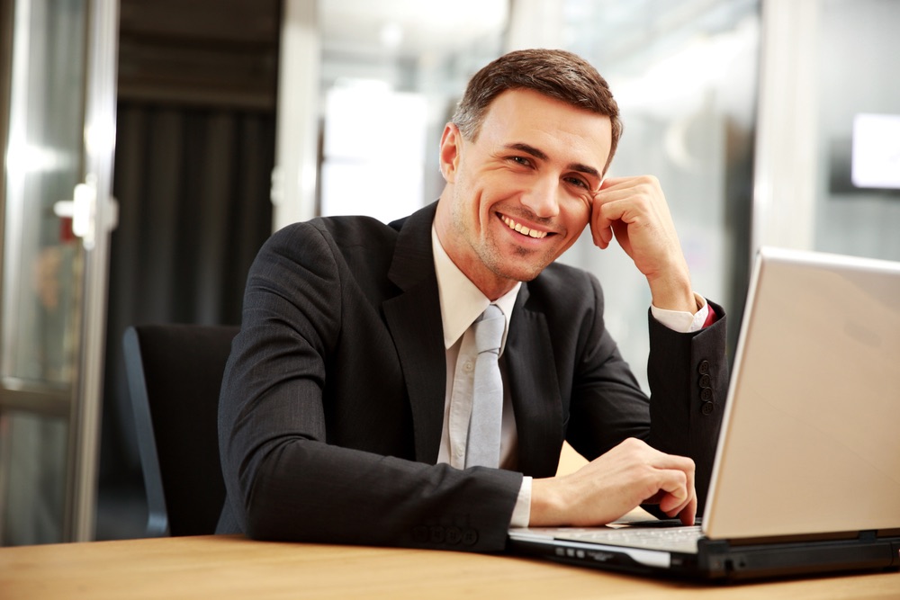Man working at his laptop smiling